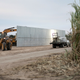 A loader grades land near a section of privately-built border wall under construction on December 11, 2019 near Mission, Texas.